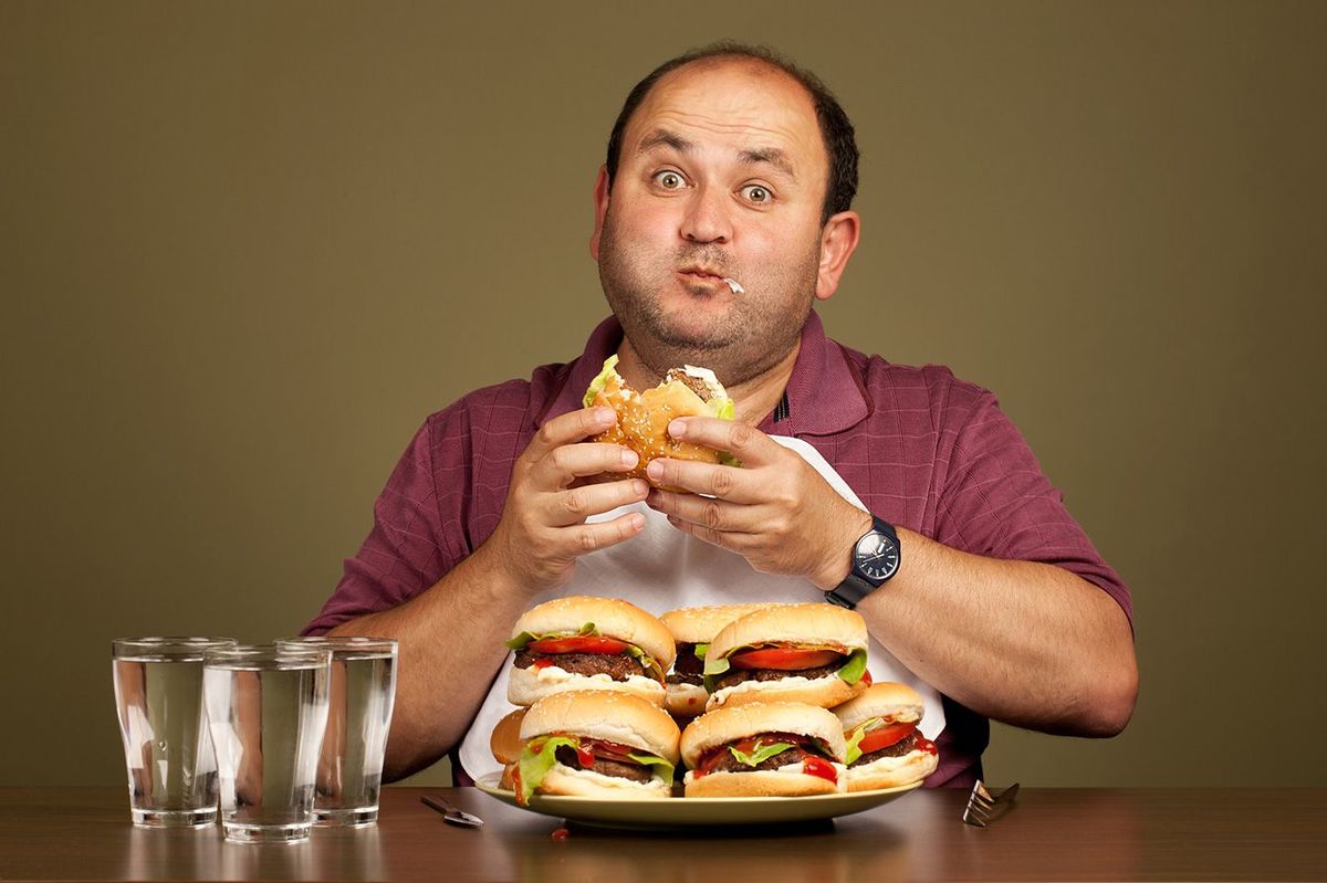 ハンバーガーを食べる男性のイメージ