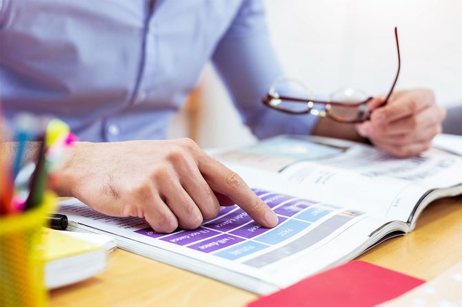 本のページで男性の指を閉じる