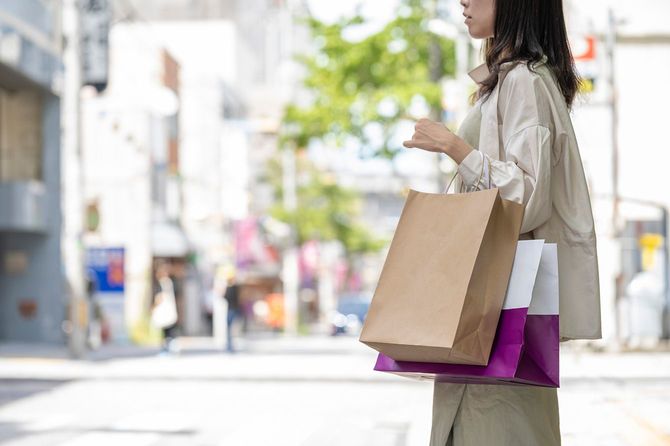 買い物をした紙袋を持つ女性