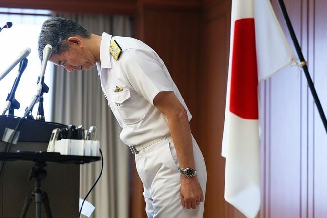 臨時記者会見で頭を下げる酒井良海上幕僚長