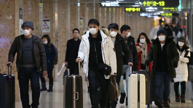 感染を防ぐためマスクをして地下道を歩く人たち＝2月18日、北海道札幌市