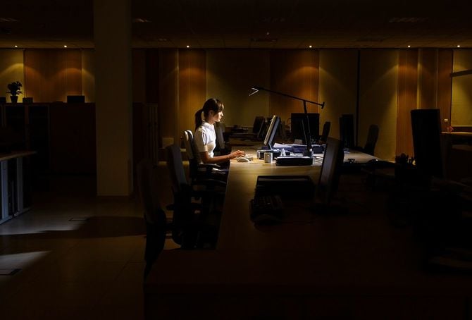 暗いオフィスに残る女性