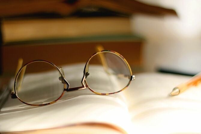 ノートの上に置かれた眼鏡と鉛筆