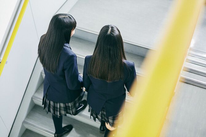 学校の階段を上る二人の女子中学生