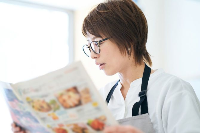 広告チラシを見ている眼鏡をかけた女性