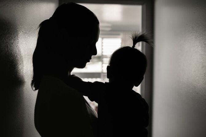 赤ちゃんを抱く母親の暗いシルエット