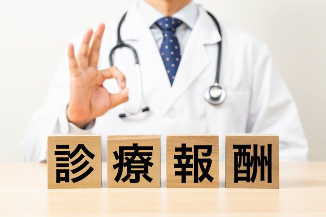 診療報酬と書かれた木製ブロックと医師