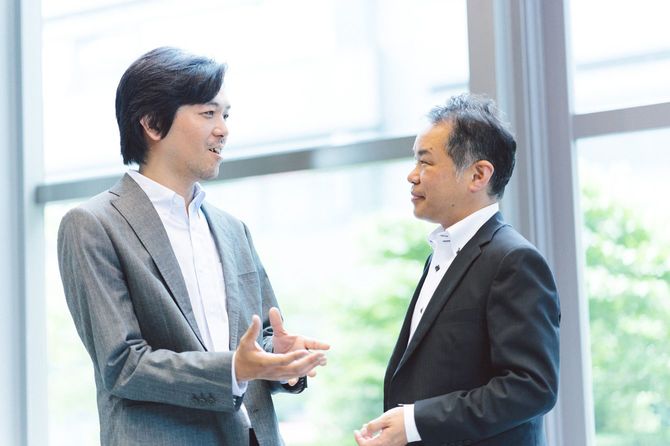 ロビーで和やかに会話する2人のビジネスマン