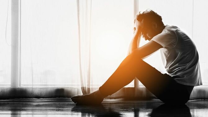 頭を抱えて座っている男性