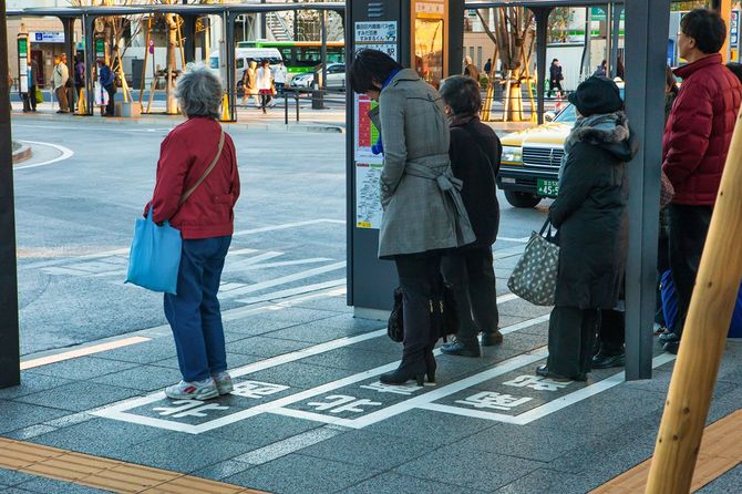 バス停に並ぶ人々