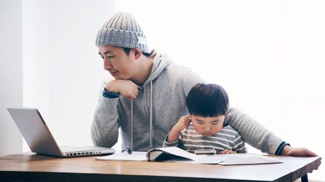 在宅勤務する父親と一緒にいる息子