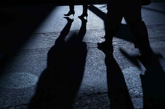 夜道で女性の後をつける男性の影