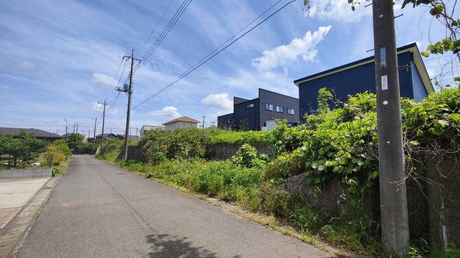 新築家屋が近年急増した成田市倉水の分譲地。元々は大半の区画が長年放棄されていた住宅地であり、新築家屋が並ぶその裏に、今でも管理不全の空き地が残る。