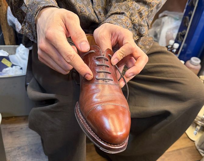 羽根(靴紐を通す穴が配置された革のパーツ)を指し「これはフォーマルな内羽根式の靴。羽根が革の内側に入り込んでいるから、これ以上開かないんですよ」と説明してくれた