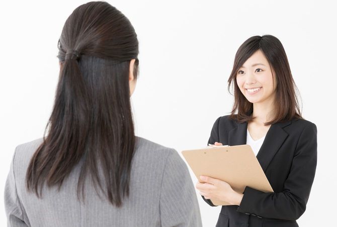 ビジネスの場で女性が女性から聞き取りをしている