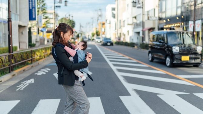 赤ちゃんと一緒に通勤する若い母親