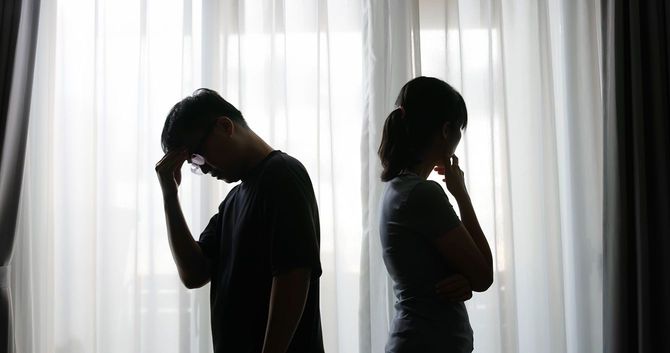 背を向けて立つ男女のシルエット