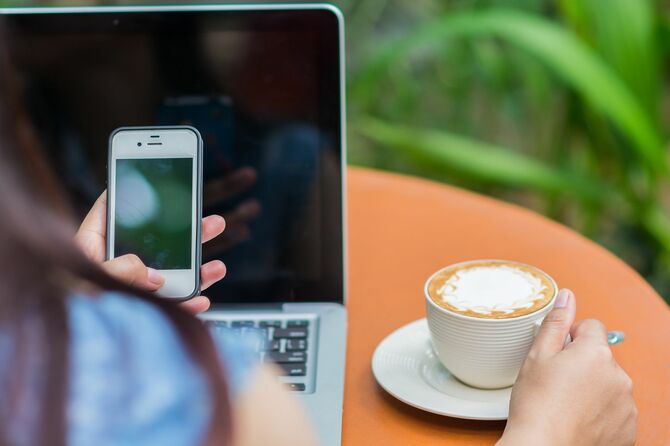 ノートPCとスマホを触る女性