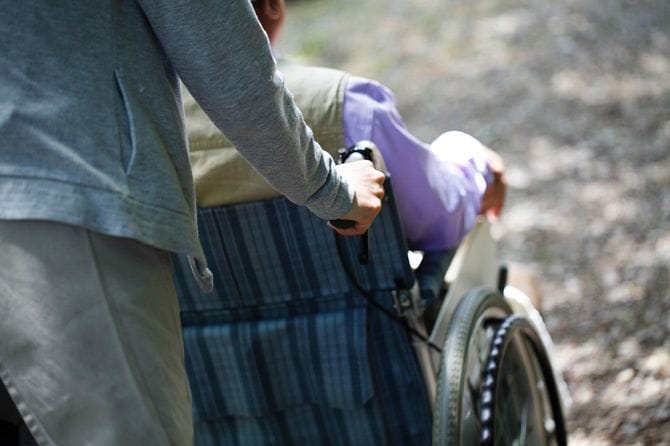 車椅子を押す介護士の後ろ姿