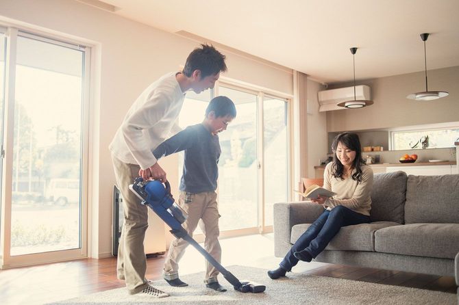 掃除機をかける父と息子