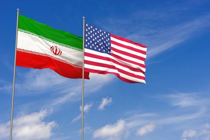 イラン国旗と星条旗が並んで青空にはためいている