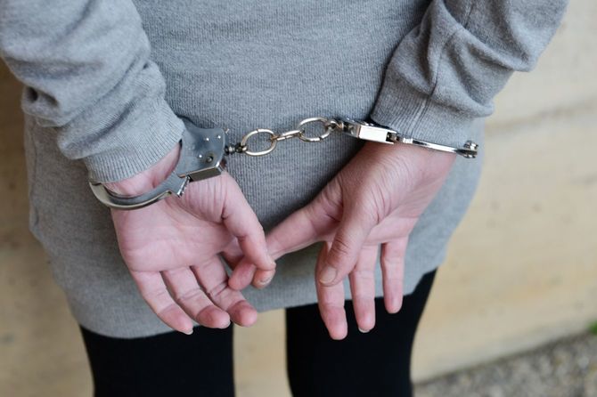 後ろ手に手錠をかけられている女性