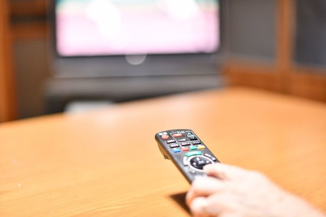 テレビのリモコンを操作する人の手