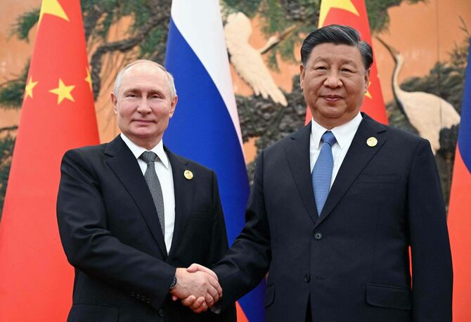 北京で握手を交わすロシアのプーチン大統領（左）と中国の習近平国家主席（＝2023年10月18日、中国・北京）
