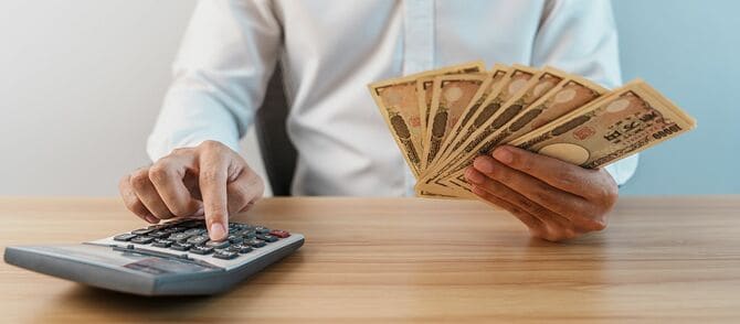 日本円紙幣を数える男の手