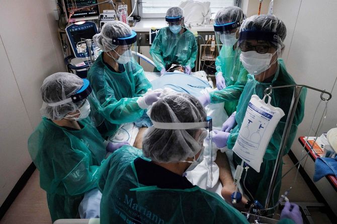 Covid-19患者のケアを行う防護具を装着した医療従事者6名