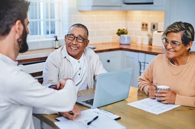 自宅でビジネスマンと握手する高齢の男性