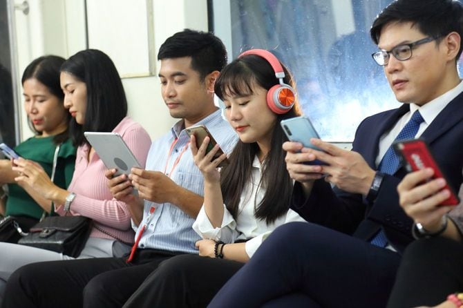 電車内でスマホを使用する人々