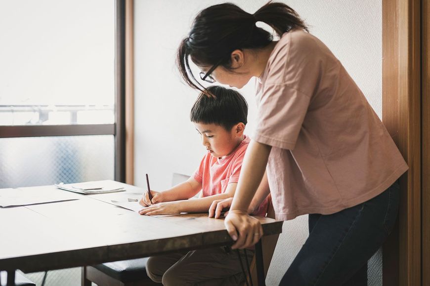 子供の勉強を見る母親