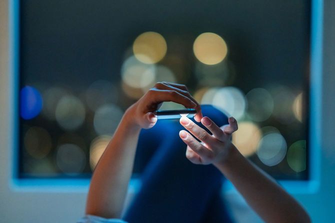 夜にスマートフォンを使用する女性