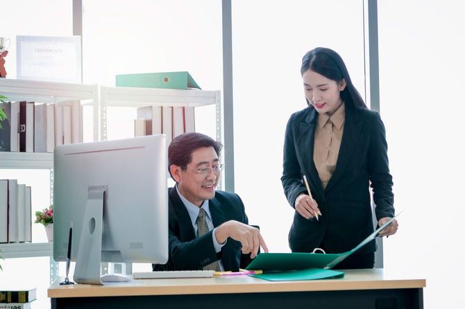 プロジェクトについて話し合う上司と秘書