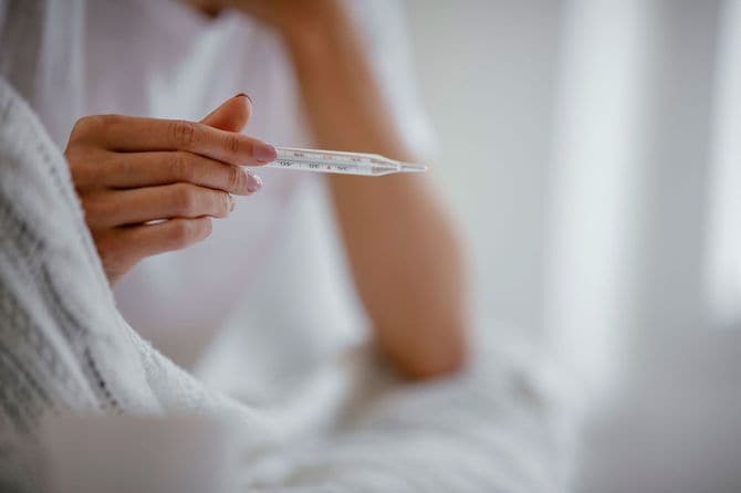 体温計で熱を測る人