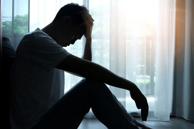 部屋の隅に座っている男性
