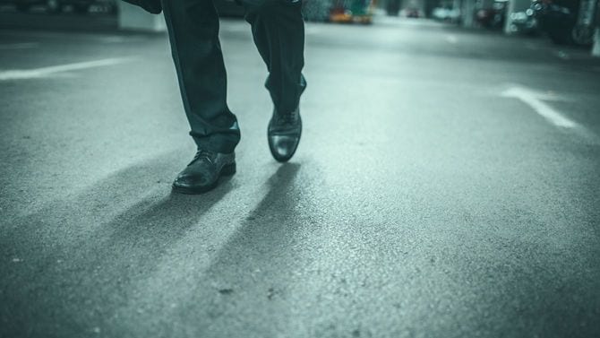 長い道のりを歩いて来てくたびれている男性の足元