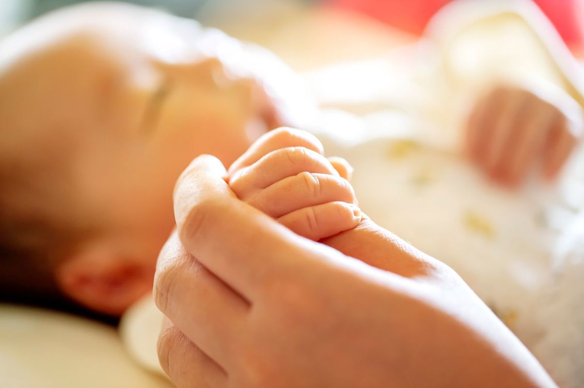 新生児が反応で親の手を握る