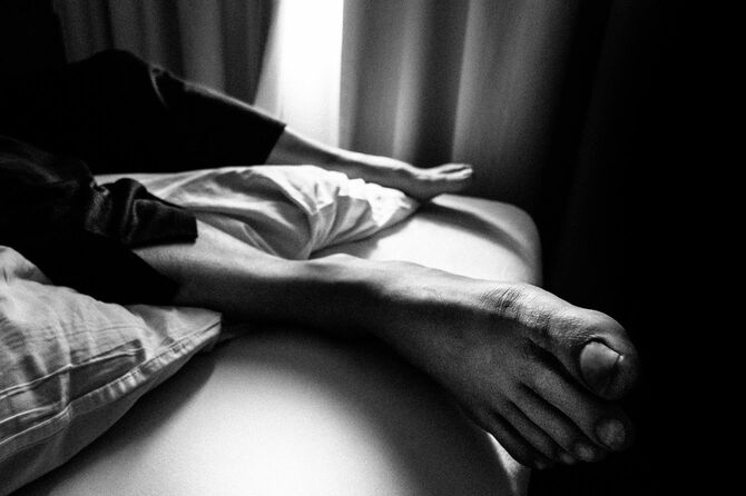 ベッドに横たわる男性の足元