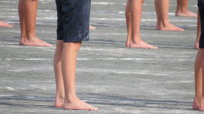 校庭に裸足で立つ子供たち