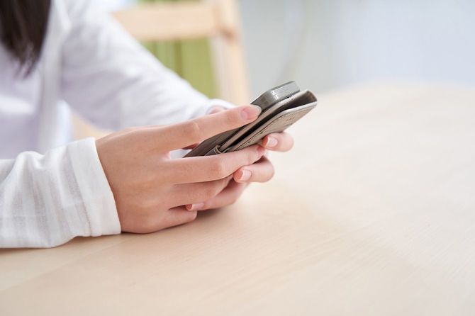 リビングでスマートフォンを見る女の子