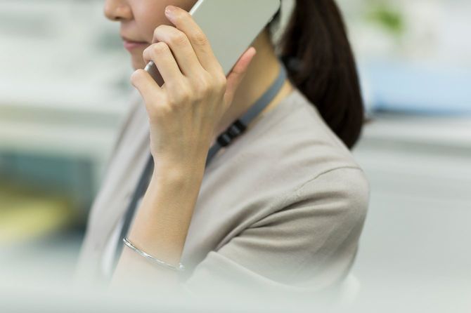 オフィスで電話応対中の女性