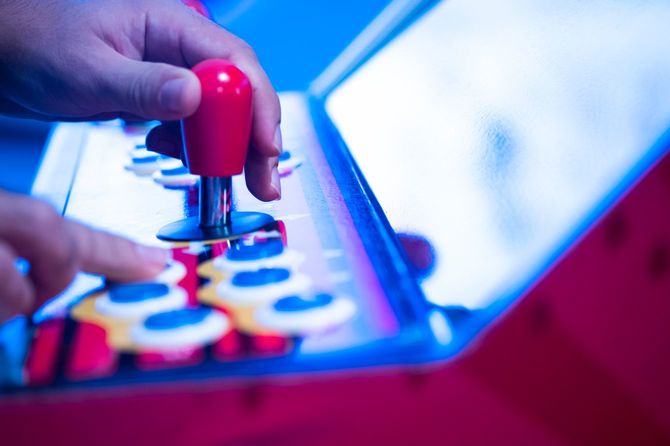 アーケードマシンで遊んでいる人の手元