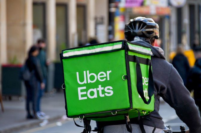 テイクアウトの食事を配達するUber Eats配達員