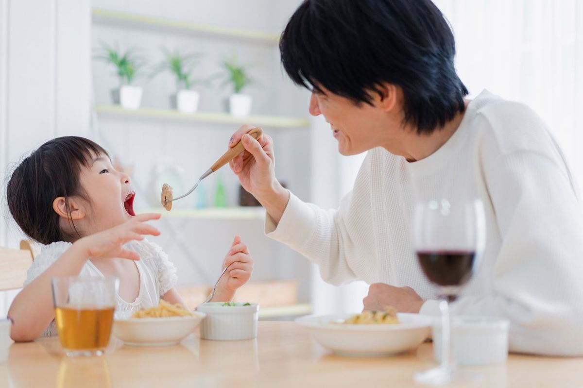 父親と食事をする小さな女の子