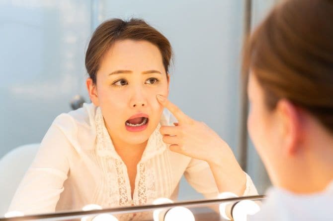 鏡をのぞき込む若い女性