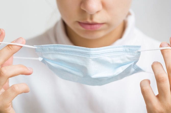 マスクをつけようとする女性