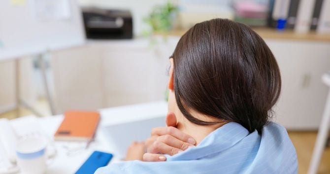 肩の痛みに思わず手を添えている女性