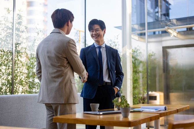 笑顔で握手をする二人のビジネスマン